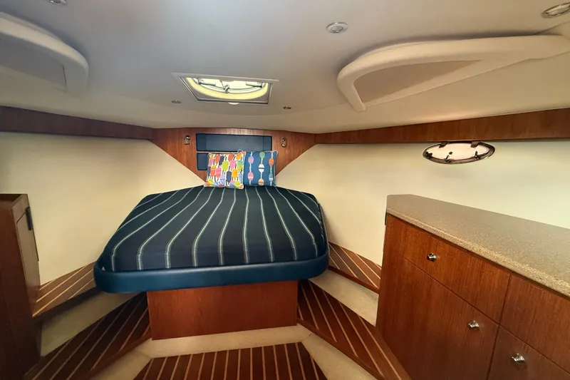 Slide: The Image of Luxurious cabin interior of 2012 Tiara Yachts 3100 Coronet with striped bedding. - 14