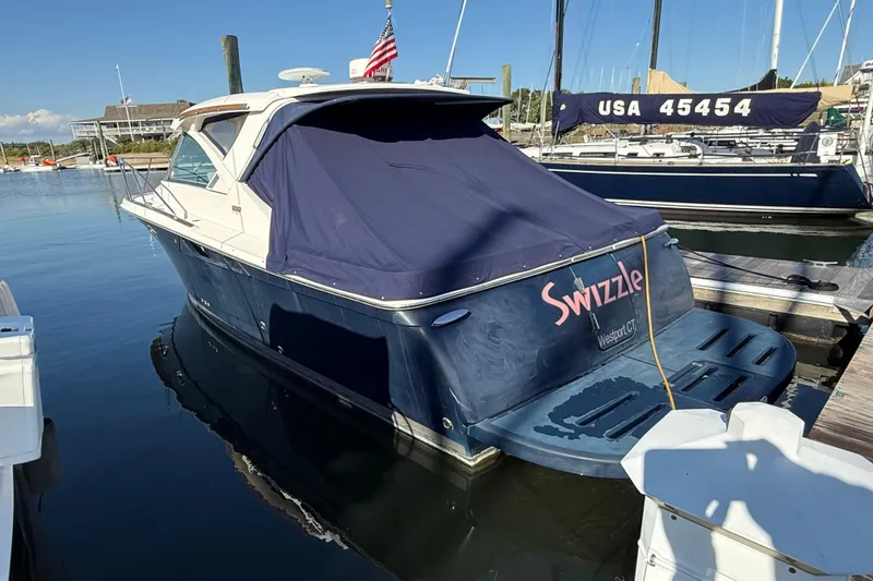 Slide: The Image of 2012 Tiara Yachts 3100 Coronet docked, covered, with "Swizzle" name visible. - 2