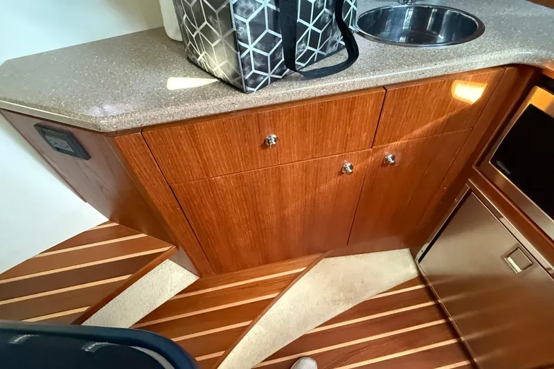 Slide: The Image of 2012 Tiara Yachts 3100 Coronet interior with wooden cabinetry and compact sink. - 25