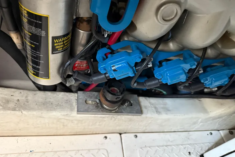 Slide: The Image of Engine components of a 2012 Tiara Yachts 3100 Coronet, featuring blue wiring and warning labels. - 31