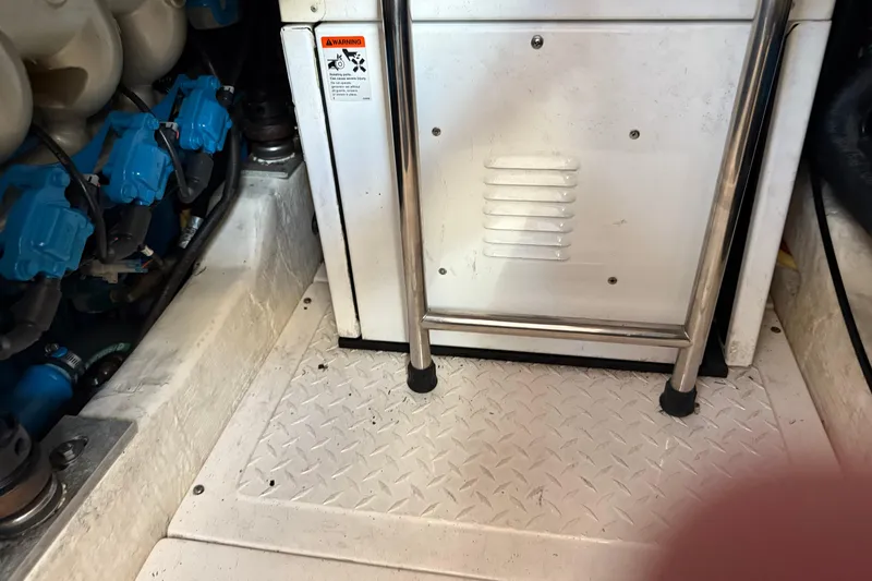 Slide: The Image of Engine compartment of a 2012 Tiara Yachts 3100 Coronet with visible components and warning label. - 32