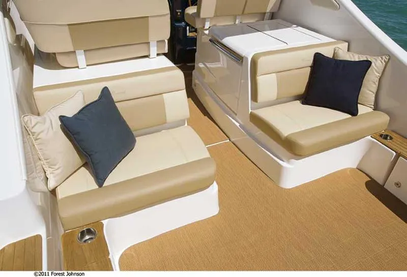 Slide: The Image of Manufacturer Provided Image: 2012 Tiara Yachts 3100 Coronet interior seating with beige cushions and navy pillows. - 7