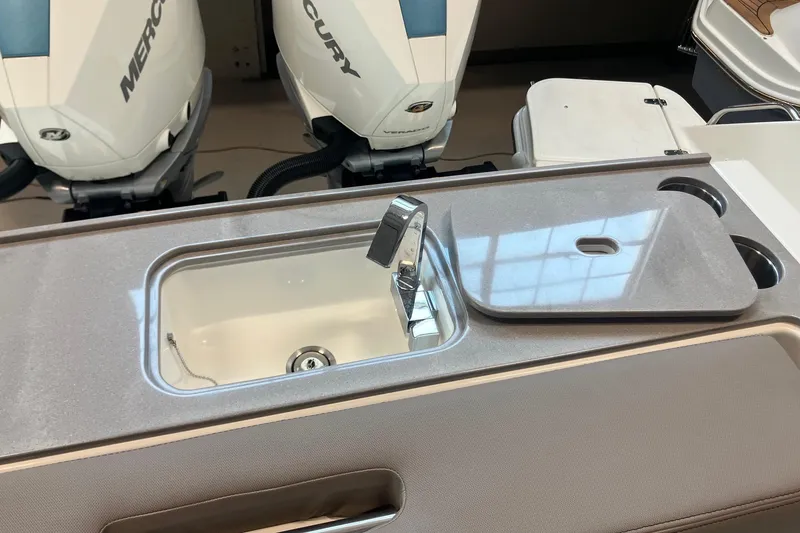 Slide: The Image of 2026 Boston Whaler 330 Vantage boat sink and countertop with Mercury engines in background. - 12