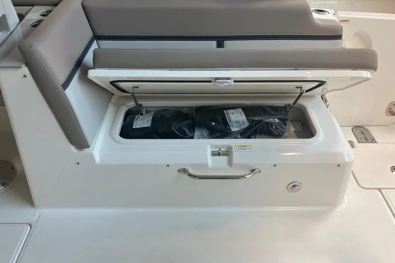 Slide: The Image of Storage compartment on a 2026 Boston Whaler 330 Vantage boat, open with items inside. - 18