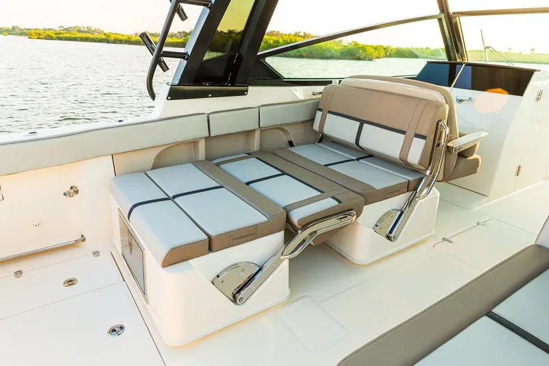 Slide: The Image of Manufacturer Provided Image: 2025 Boston Whaler 330 Vantage boat interior with adjustable seating by the water. - 40