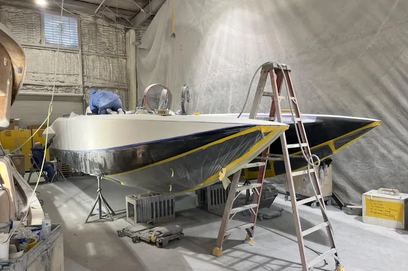 Slide: The Image of 2026 Nor-Tech 4000 Roadster boat under construction in a workshop with ladder and tools. - 11