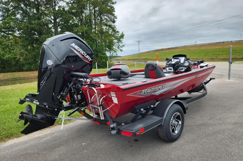 Slide: The Image of 2026 Ranger RT178 boat with Mercury engine, parked on a road near greenery. - 2