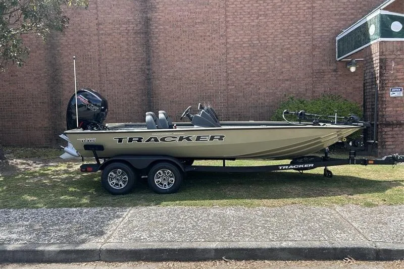 The Image of 2026 Tracker Pro Team 195 boat on trailer, parked beside a brick wall. - 0