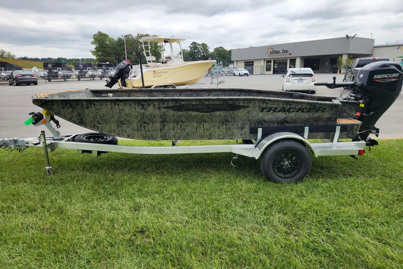 Slide: The Image of 2026 Tracker Grizzly 1650 T Prairie Wings Edition boat on trailer, parked on grass. - 5