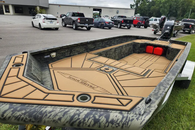 Slide: The Image of 2026 Tracker Grizzly 1650 T Prairie Wings Edition boat with custom deck design in parking lot. - 7