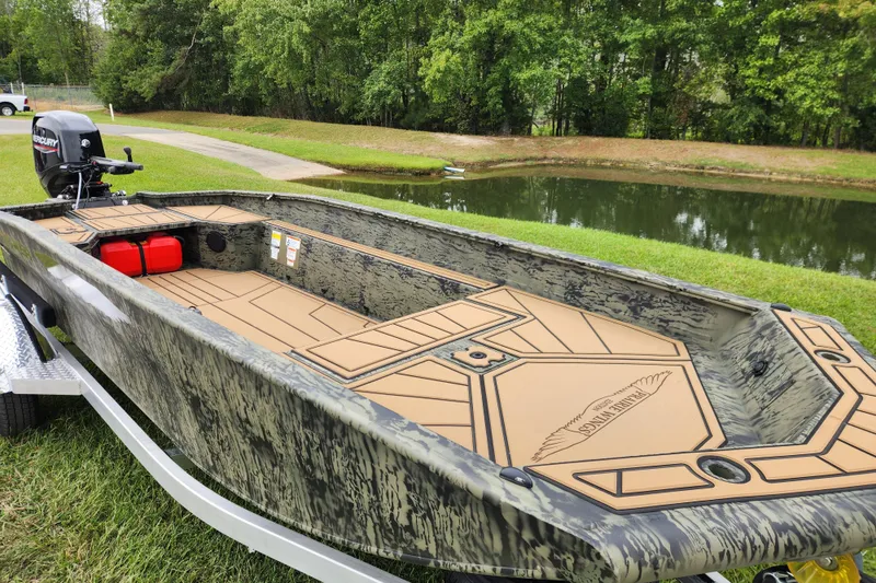 Slide: The Image of 2026 Tracker Grizzly 1650 T Prairie Wings Edition boat by a serene pond. - 8