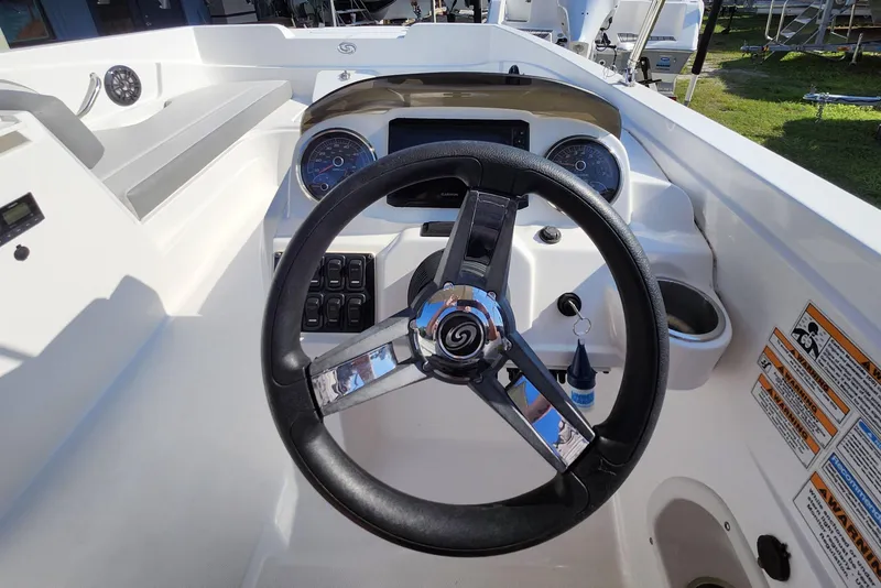 Slide: The Image of 2023 Hurricane SunDeck Sport 205 OB boat dashboard with steering wheel and controls. - 10
