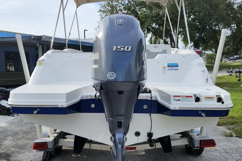 Slide: The Image of 2023 Hurricane SunDeck Sport 205 OB boat with Yamaha 150 outboard motor, parked outdoors. - 21