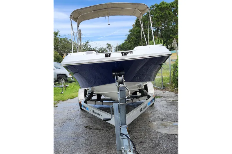 Slide: The Image of 2023 Hurricane SunDeck Sport 205 OB boat on trailer, parked outdoors. - 24