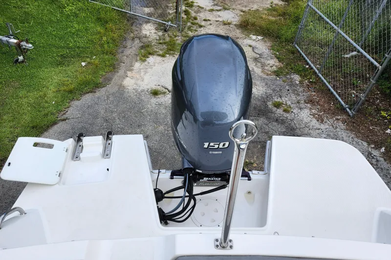 Slide: The Image of 2023 Hurricane SunDeck Sport 205 OB with Yamaha 150 engine, parked on concrete. - 25