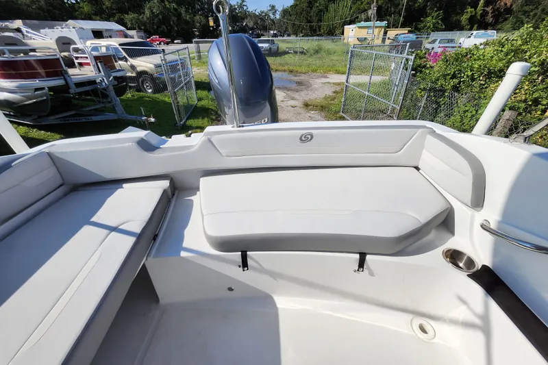 Slide: The Image of 2023 Hurricane SunDeck Sport 205 OB boat interior with cushioned seating and outboard motor. - 5