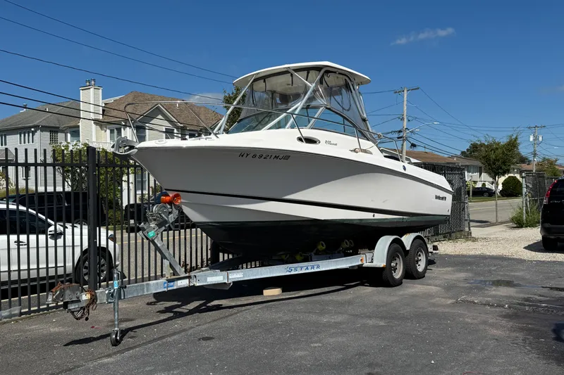 The Image of 2012 Wellcraft 210 Coastal boat on trailer, parked in residential area. - 1