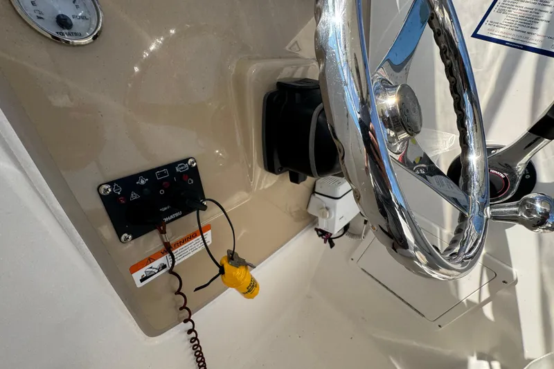 Slide: The Image of 2012 Wellcraft 210 Coastal boat dashboard with steering wheel and control panel. - 14