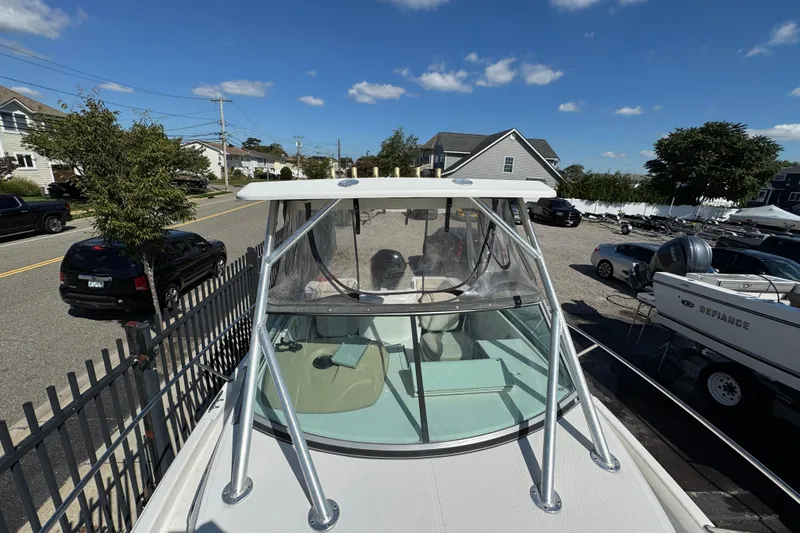 Slide: The Image of 2012 Wellcraft 210 Coastal boat parked in a residential area under a clear blue sky. - 23