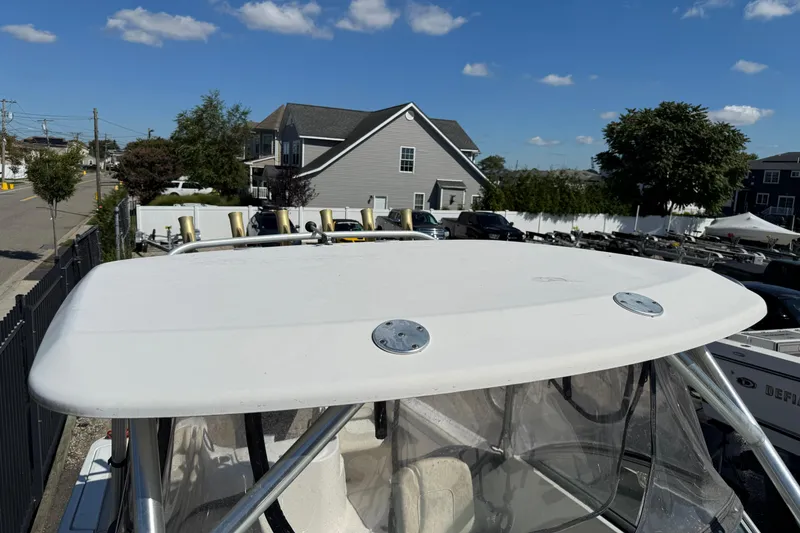 Slide: The Image of 2012 Wellcraft 210 Coastal boat with hardtop, parked in a residential area under clear skies. - 24