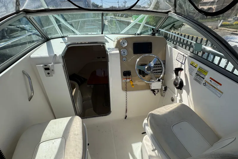 Slide: The Image of 2012 Wellcraft 210 Coastal boat interior with steering wheel and cabin entrance. - 25
