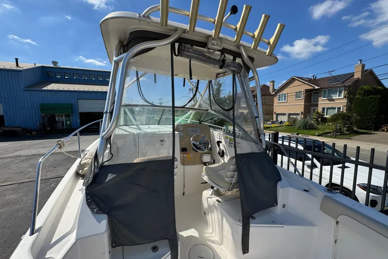Slide: The Image of 2012 Wellcraft 210 Coastal boat interior with steering wheel and seating, parked outdoors. - 6