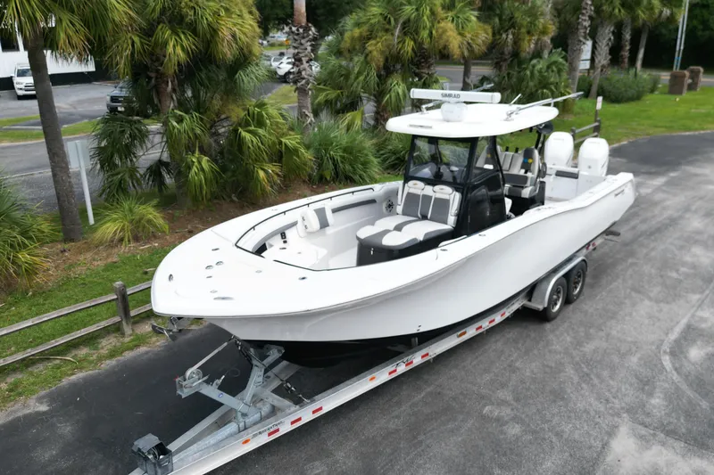 Slide: The Image of 2020 Tidewater 320 CC Adventure boat on calm water, featuring dual Mercury engines. - 2