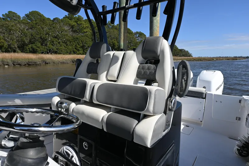 Slide: The Image of 2020 Tidewater 320 CC Adventure boat interior with dual helm seats and steering wheel. - 30