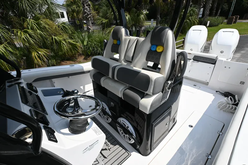 Slide: The Image of 2020 Tidewater 320 CC Adventure boat on trailer, surrounded by palm trees. - 9