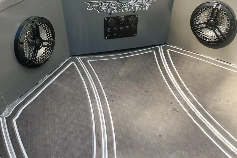 Slide: The Image of 2024 Reaper Boats 550 on trailer, parked outdoors with trees in background. - 4