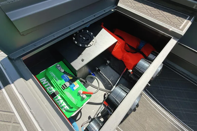 Slide: The Image of Open storage compartment in 2024 Reaper Boats 550, showing battery and life jacket. - 9