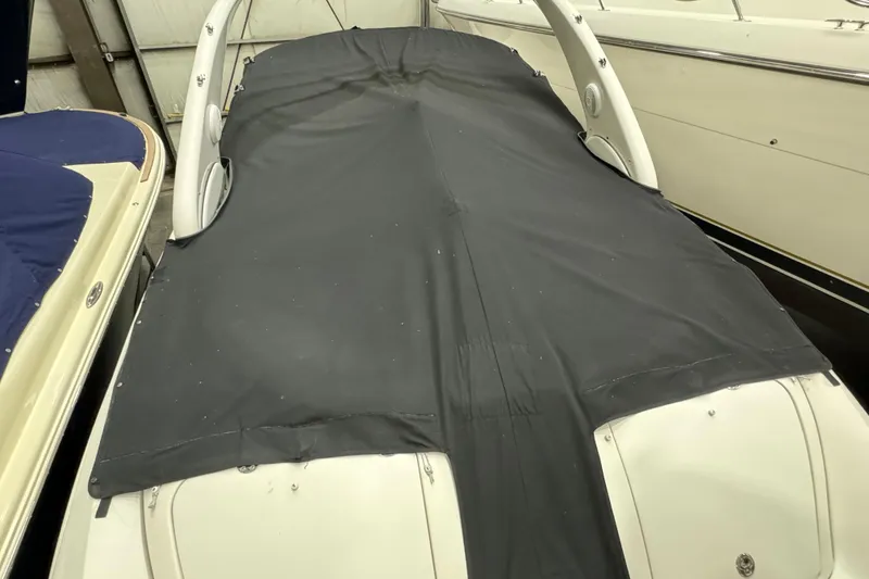 Slide: The Image of 2006 Sea Ray 290 Select EX boat with black cover in storage. - 11