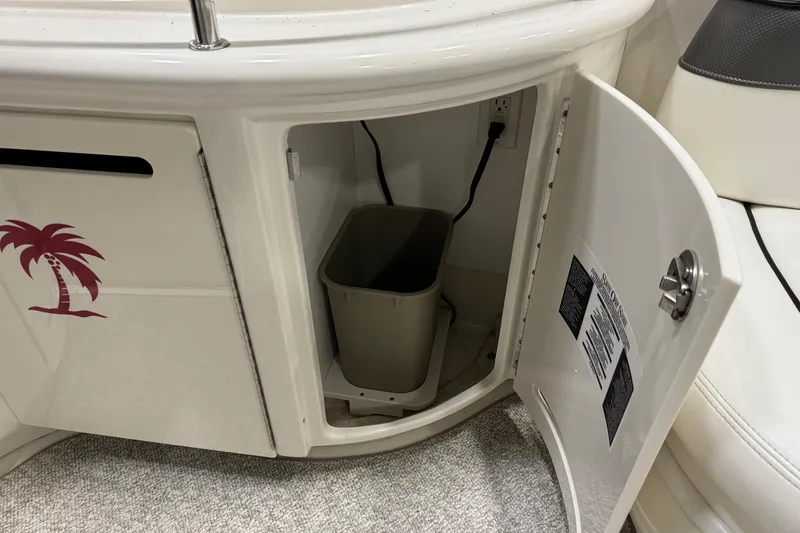 Slide: The Image of Open cabinet on 2006 Sea Ray 290 Select EX boat, showing interior storage with trash bin. - 18