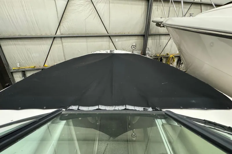 Slide: The Image of 2006 Sea Ray 290 Select EX boat with black cover in storage facility. - 31