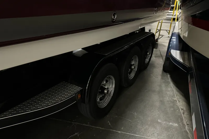 Slide: The Image of 2006 Sea Ray 290 Select EX boat on a triple-axle trailer in a storage facility. - 4