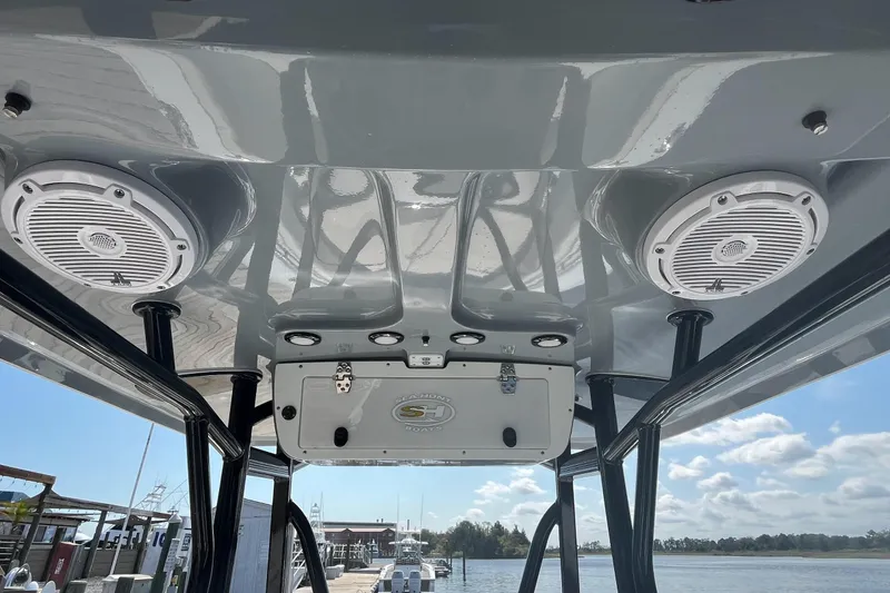 Slide: The Image of 2022 Sea Hunt Ultra 219 boat speakers and console under a clear sky. - 13