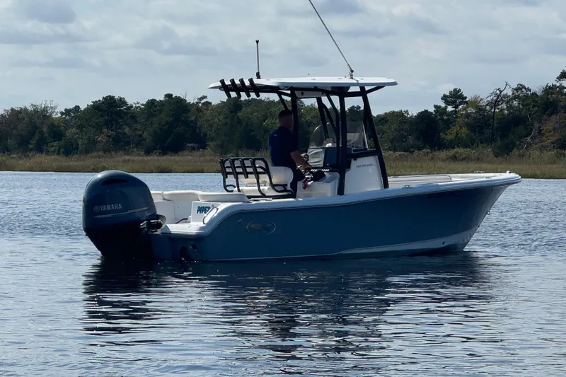 Slide: The Image of 2022 Sea Hunt Ultra 219 boat on calm water with Yamaha engine. - 19