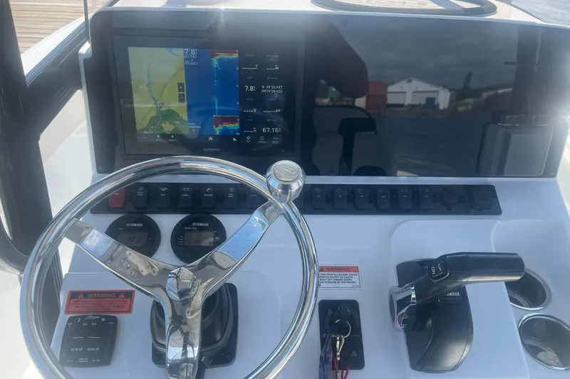 Slide: The Image of Control panel of 2022 Sea Hunt Ultra 219 boat with navigation display and steering wheel. - 3