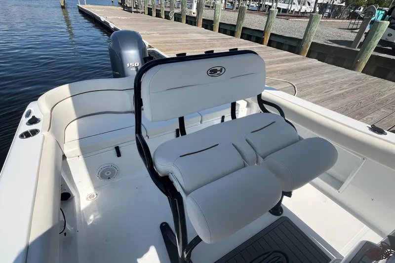 Slide: The Image of 2022 Sea Hunt Ultra 219 boat interior with seating and dock view. - 7