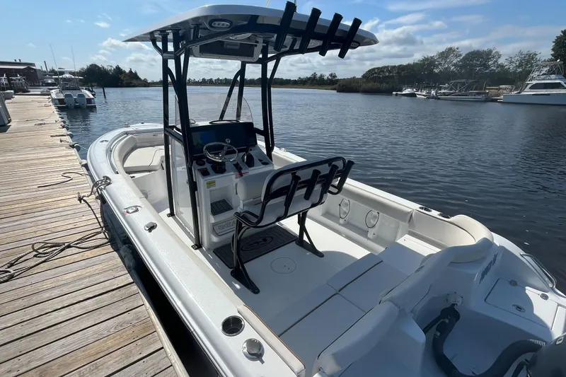 Slide: The Image of 2022 Sea Hunt Ultra 219 boat docked by a wooden pier on a sunny day. - 8