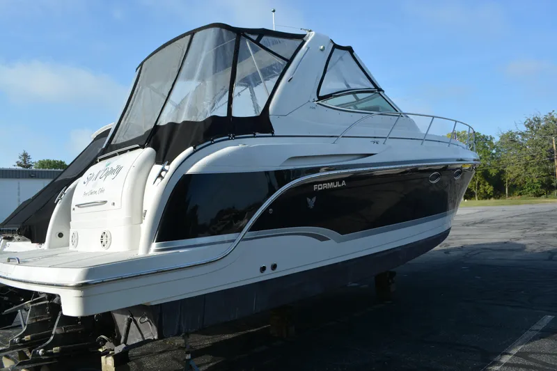 Slide: The Image of 2006 Formula 34 Performance Cruiser boat with black canopy, parked on a lot. - 2