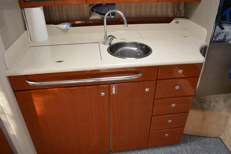 Slide: The Image of 2006 Formula 34 Performance Cruiser kitchen with sink, wooden cabinets, and countertop. - 22