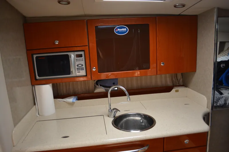 Slide: The Image of 2006 Formula 34 Performance Cruiser kitchen with microwave, sink, and wooden cabinets. - 23