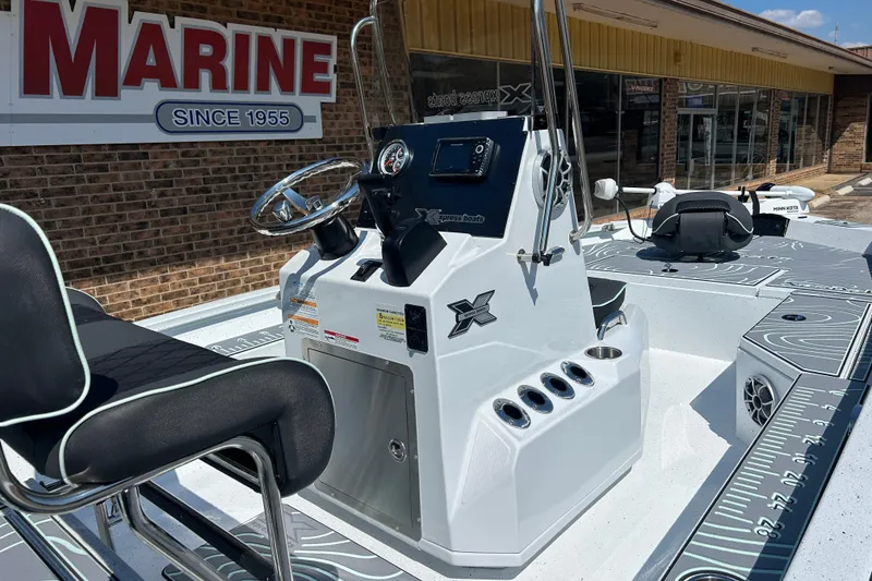 Slide: The Image of 2026 Xpress H20B Bay boat interior with steering console and seating, displayed at a marine dealership. - 3