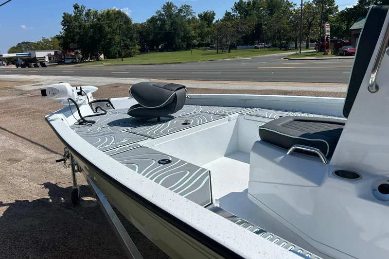 Slide: The Image of 2026 Xpress H20B Bay boat with sleek seating and modern design, parked near a road. - 6