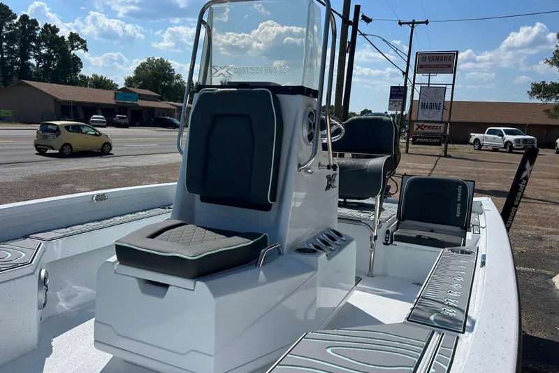 Slide: The Image of 2026 Xpress H20B Bay boat with seating, parked outdoors near a road. - 7