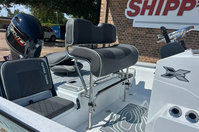 Slide: The Image of 2026 Xpress H20B Bay boat interior with seating and Yamaha engine, displayed outdoors. - 9