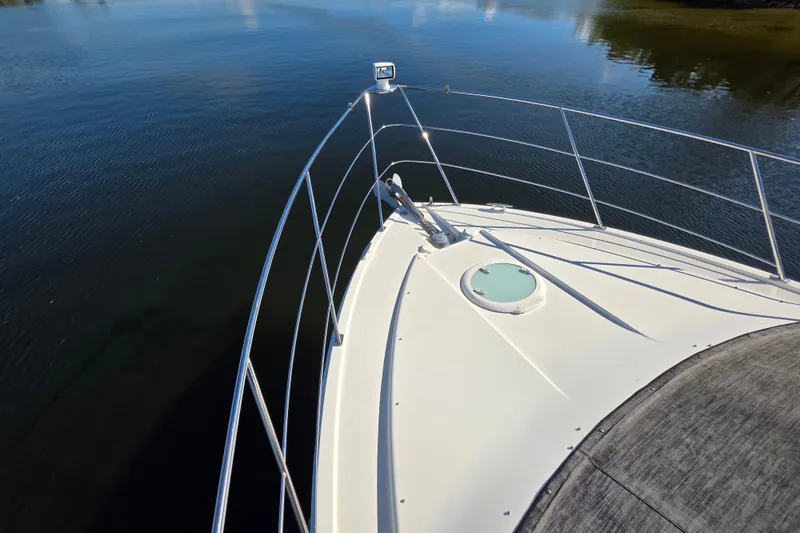 Slide: The Image of 2005 Carver 41 Cockpit Motor Yacht bow on calm water, showcasing sleek design. - 11