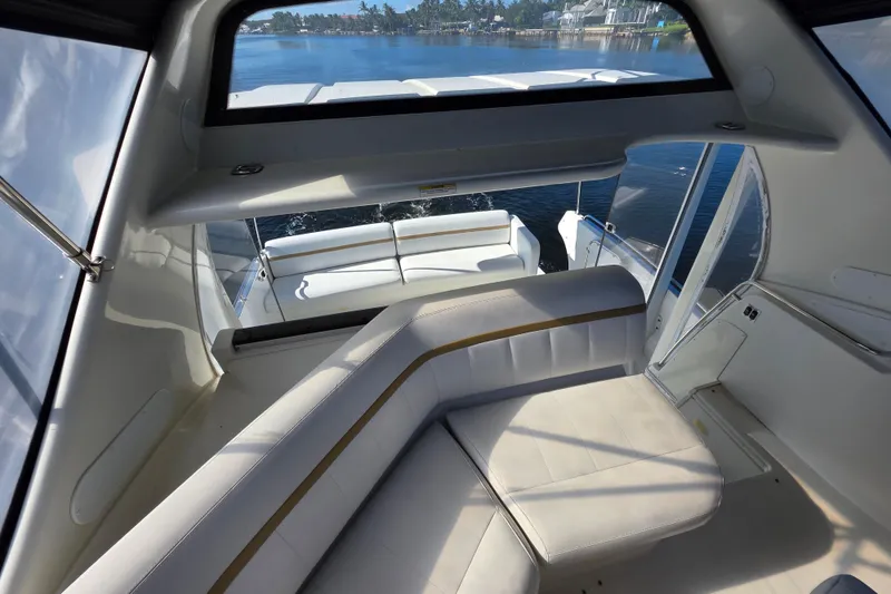 Slide: The Image of 2005 Carver 41 Cockpit Motor Yacht interior with white seating and scenic water view. - 13