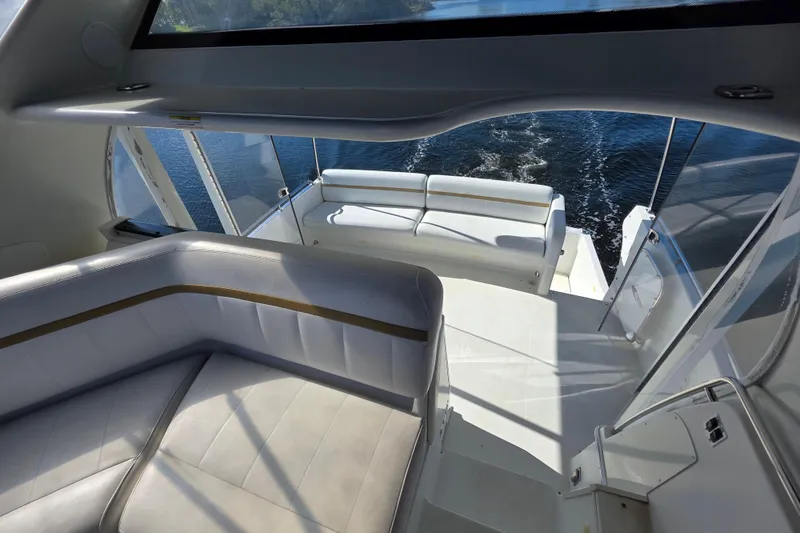 Slide: The Image of 2005 Carver 41 Cockpit Motor Yacht interior with white seating and water view. - 14